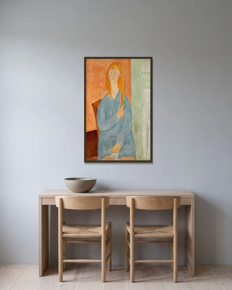 Sitzendes junges Mädchen mit aufgelöstem Haar (Mädchen in Blau) von Amedeo Modigliani gerahmt an einer Wand