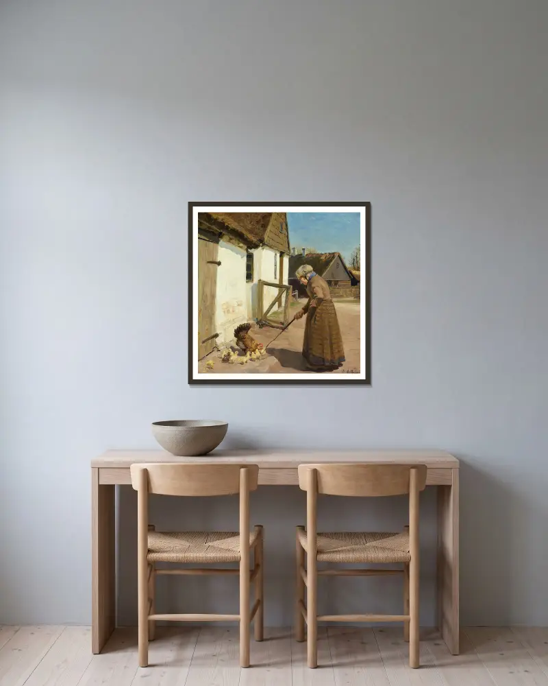 En høne med sine kyllinger av Hans Andersen Brendekilde inramad på en vägg