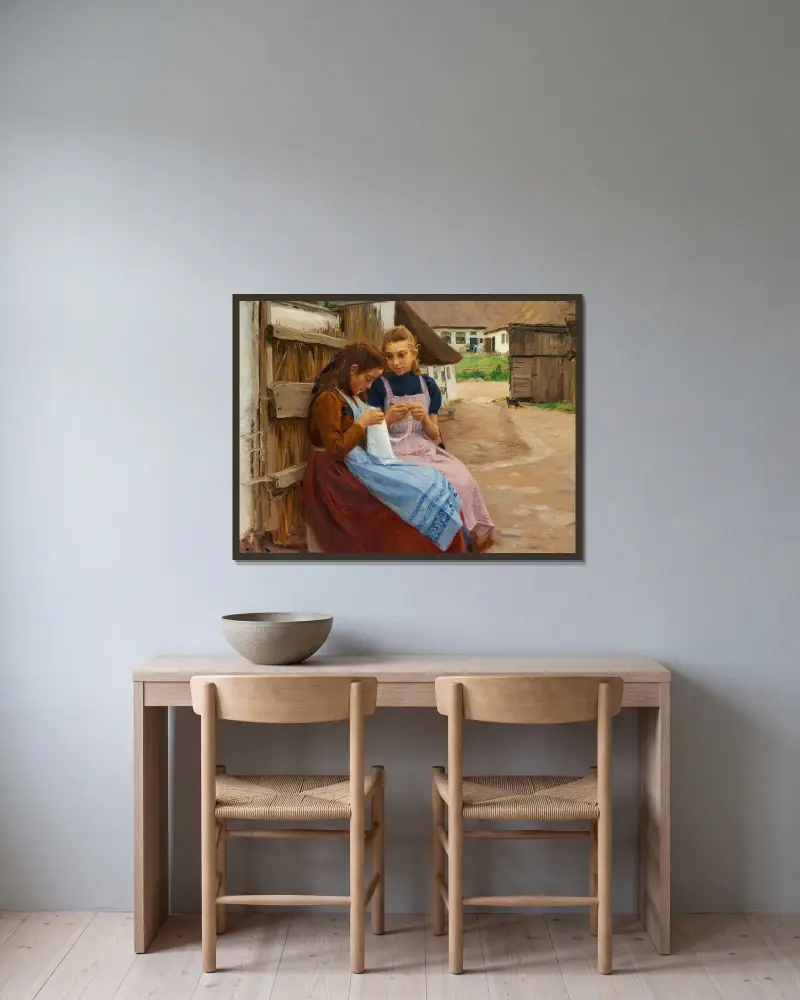 Två flickor med handarbete sittande på en gårdsplan av Hans Andersen Brendekilde inramad på en vägg