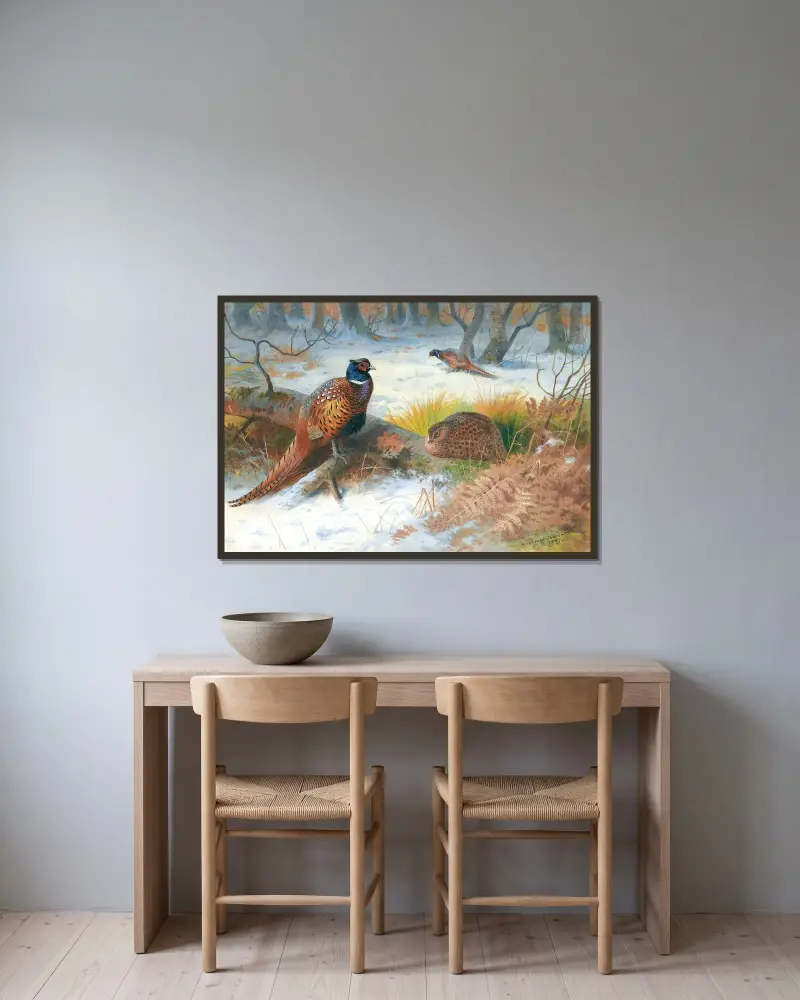 Fasaner i snö av Archibald Thorburn inramad på en vägg