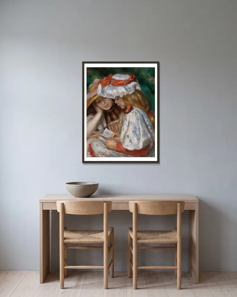 Zwei lesende Mädchen von Pierre-Auguste Renoir gerahmt an einer Wand
