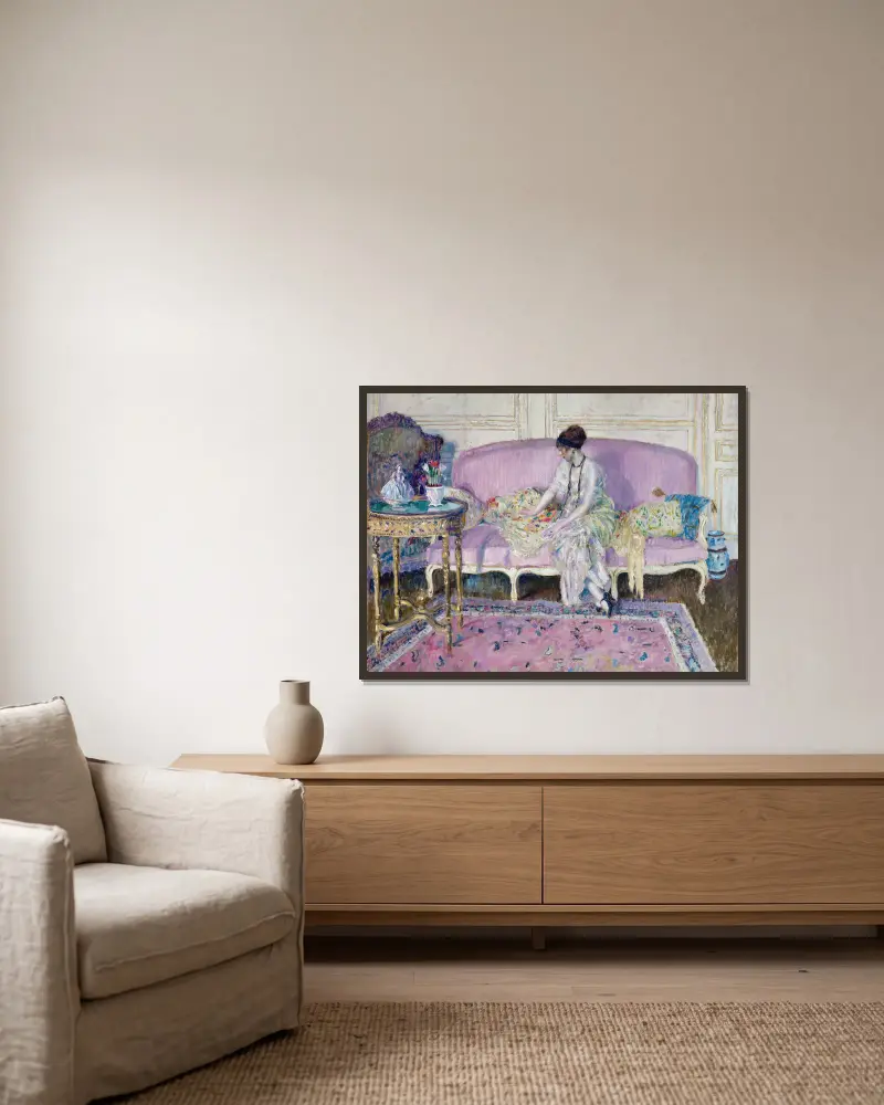 Kvinna sittande på soffa i interiör av Frederick Carl Frieseke inramad på en vägg