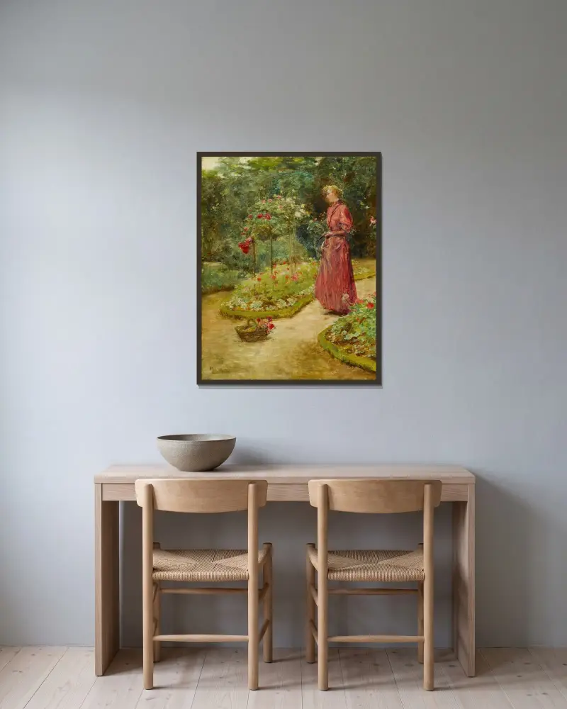 Kvinna som klipper rosor i en trädgård av Childe Hassam inramad på en vägg