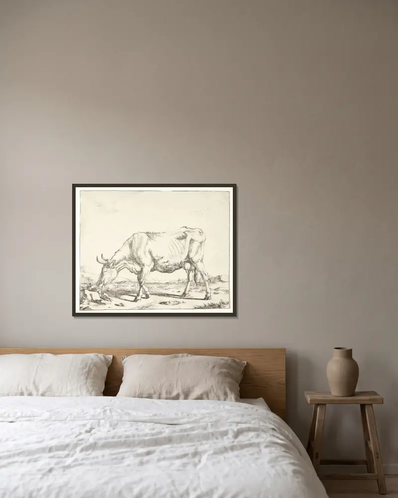 Grasende Kuh von Marcus de Bye gerahmt an einer Wand