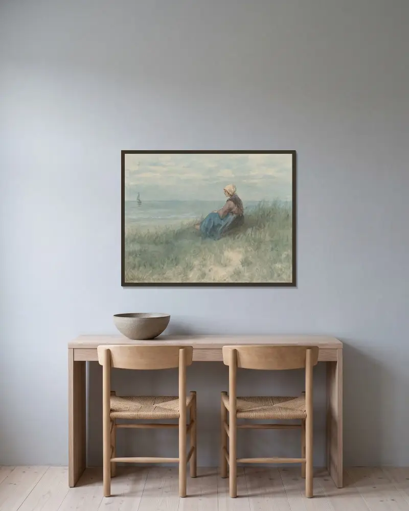 En kvinna sitter på en sanddyna och ser ut mot havet av Jozef Israëls inramad på en vägg