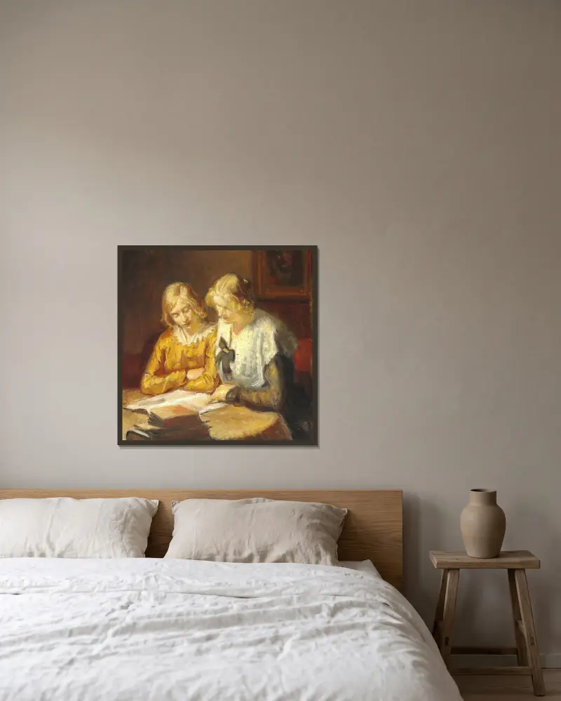 To unge piger sidder ved bordet og læser i en bog av Michael Ancher inramad på en vägg