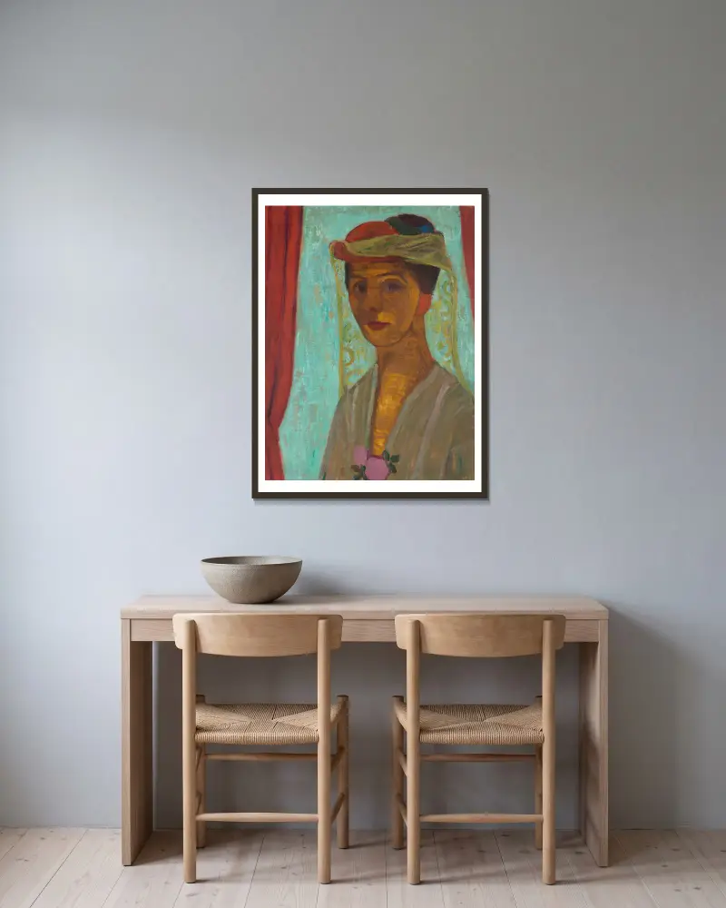 Selbstporträt mit Hut und Schleier von Paula Modersohn-Becker gerahmt an einer Wand
