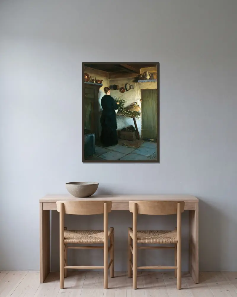 Kitchen interior. The artist’s wife arranging flowers av Viggo Johansen inramad på en vägg