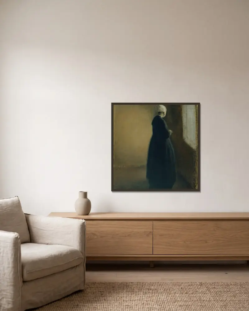 An old woman standing by a window av Vilhelm Hammershøi inramad på en vägg