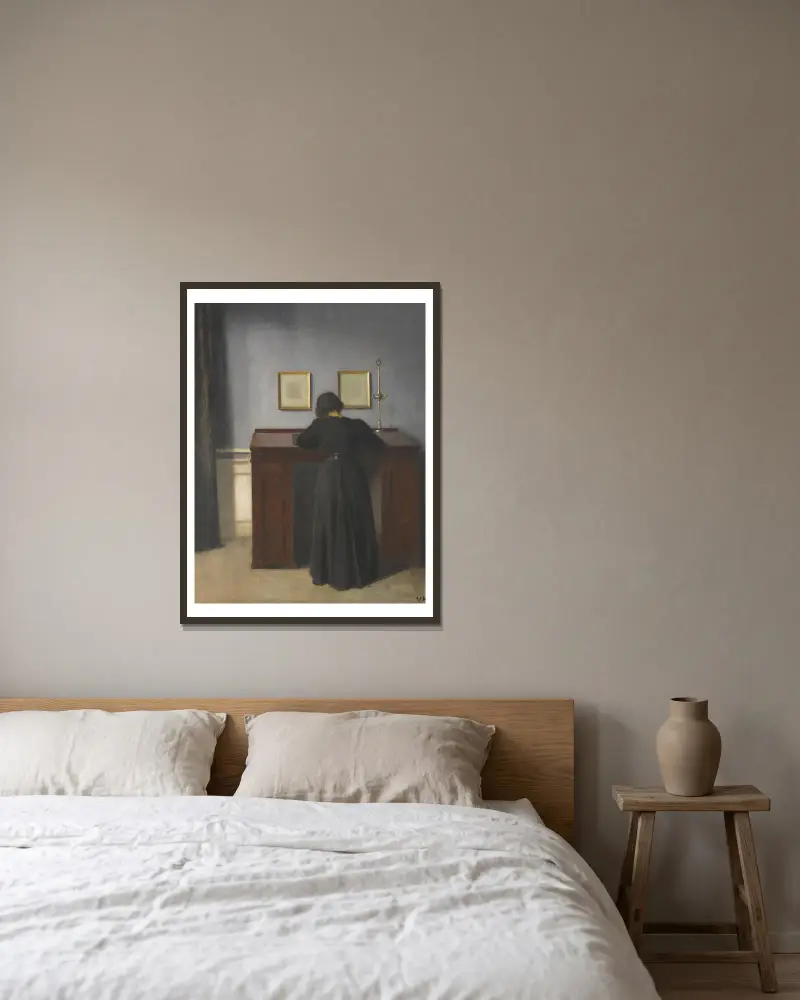 Ida am Schreibtisch stehend von Vilhelm Hammershøi gerahmt an einer Wand