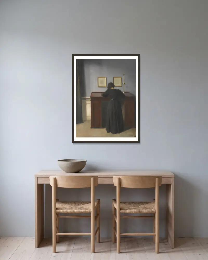 Ida am Schreibtisch stehend von Vilhelm Hammershøi gerahmt an einer Wand