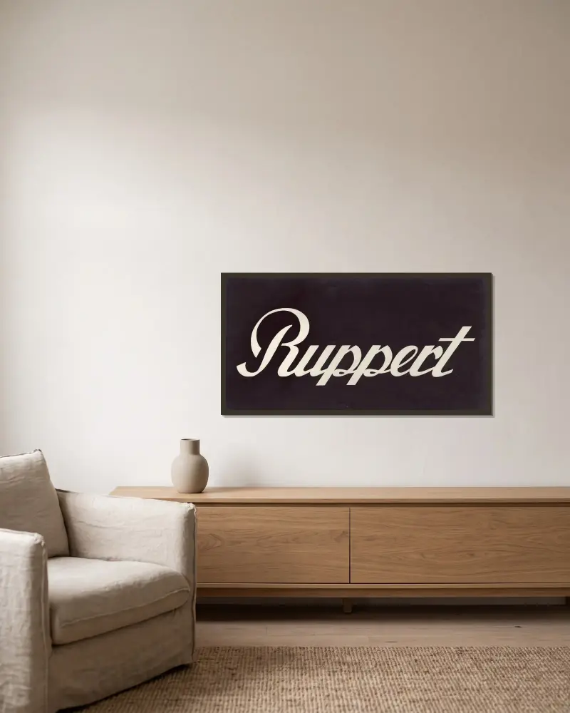 Stylized logo for Ruppert Beer av Winold Reiss inramad på en vägg