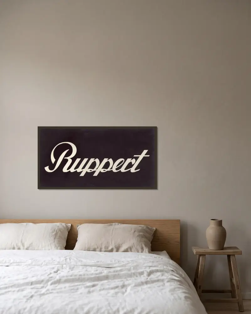 Stylized logo for Ruppert Beer av Winold Reiss inramad på en vägg